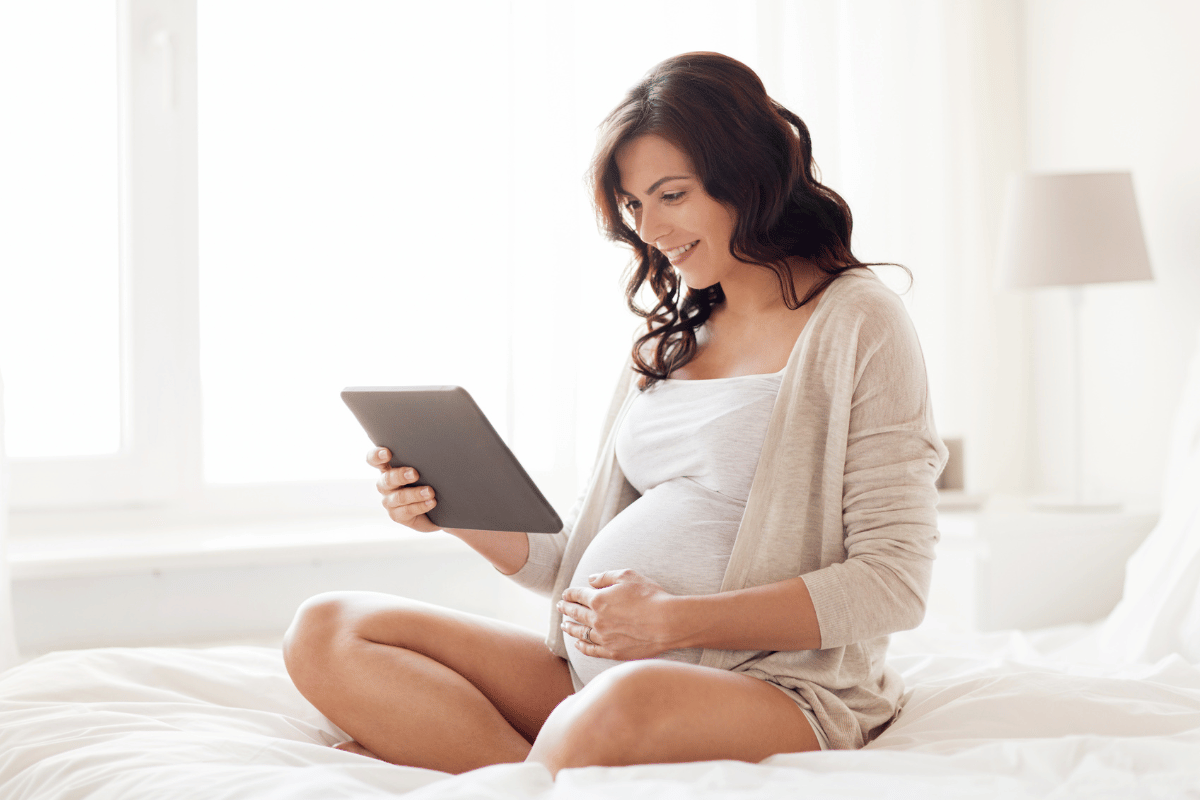 pregnant woman looking at tablet device