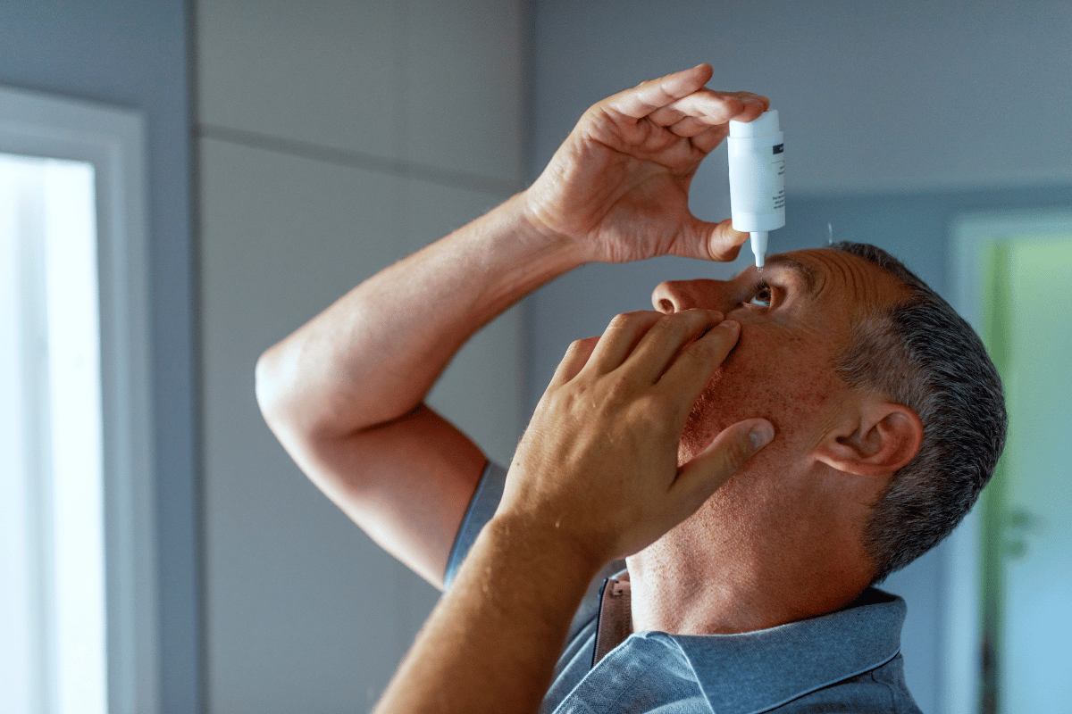 a man putting in eye drops for dry eye